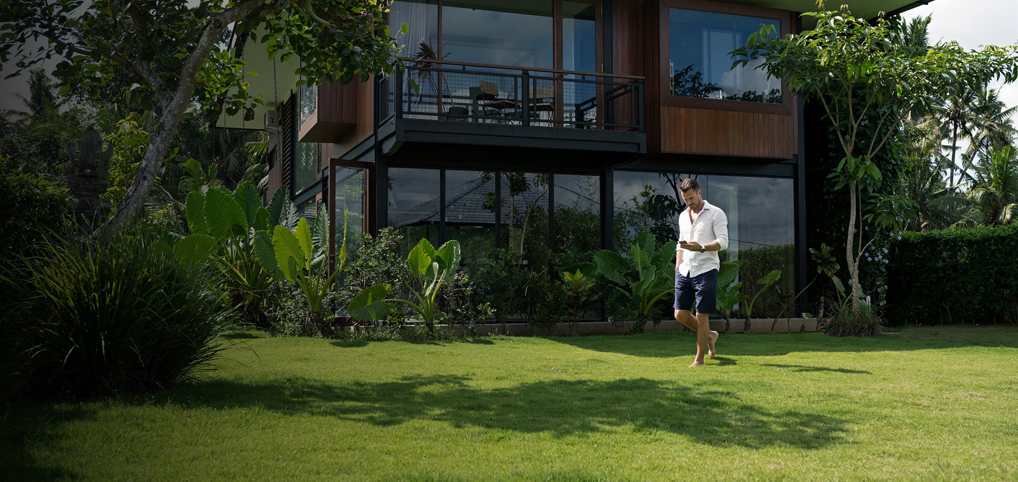 Homepage hero Man on phone in grass yard 2000x947 Man on phone in grass yard